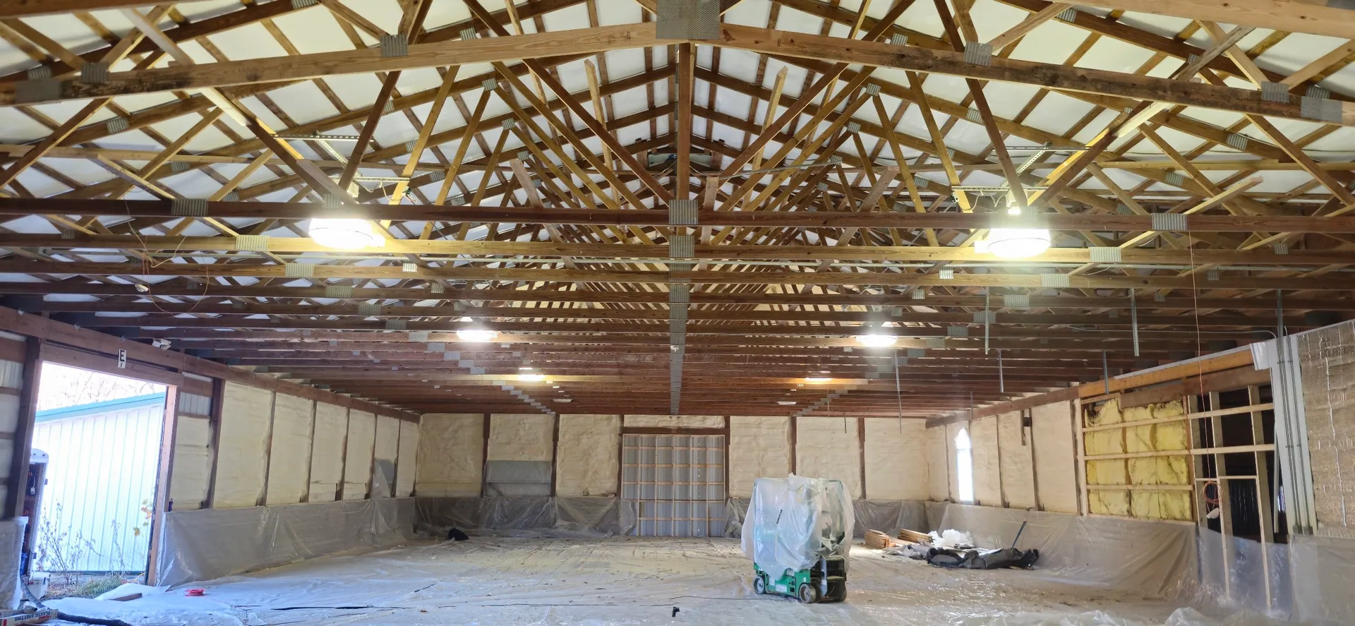 Wide view of pole barn interior with exposed roof trusses