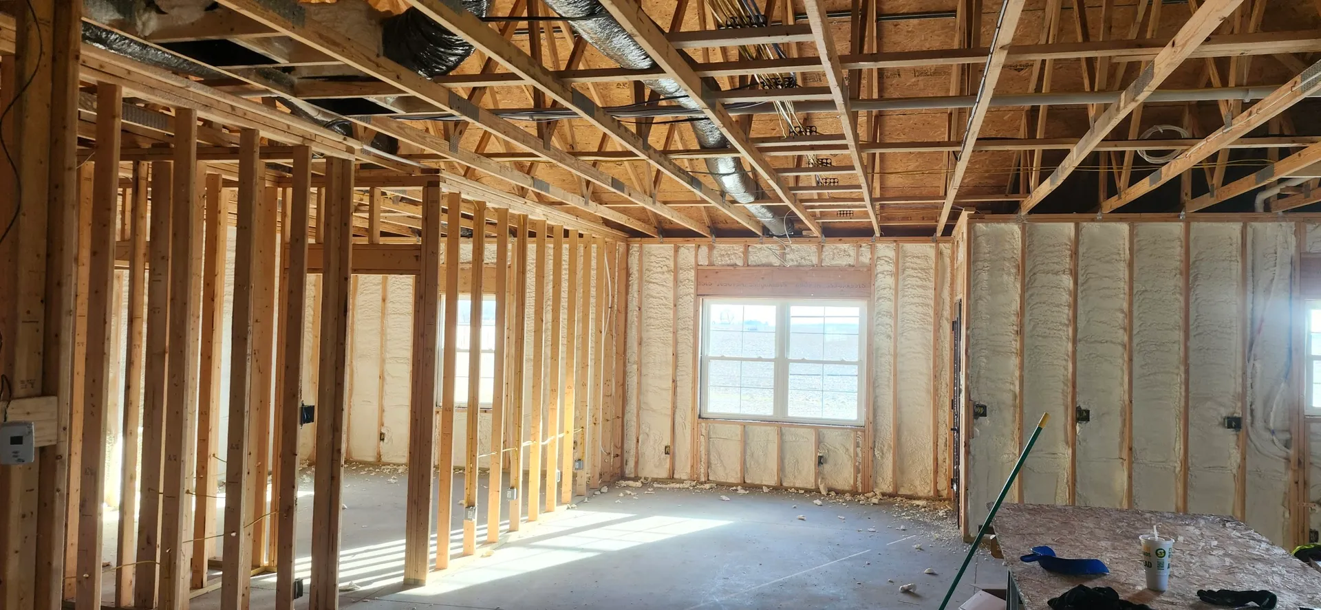 Residential new construction with spray foam on walls and ceiling framing
