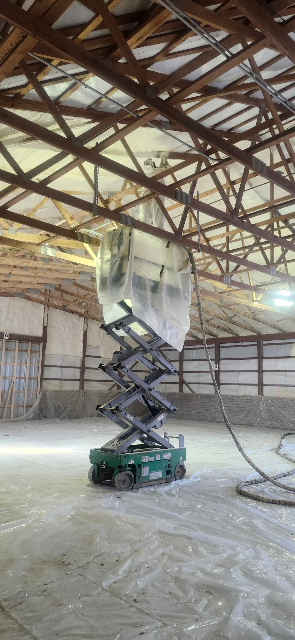 Scissor lift with sheeting in pole barn